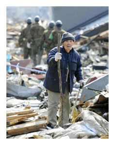 An elderly man looks for his house through the rubble in Rikuzentakata, Iwate Prefecture, northern Japan.