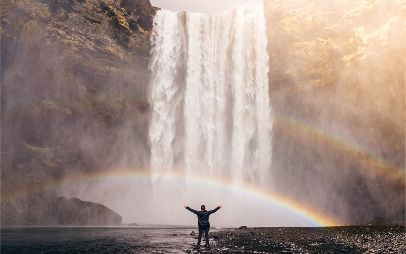 Man in front of waterfall