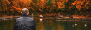 Man sitting by the water in autumn