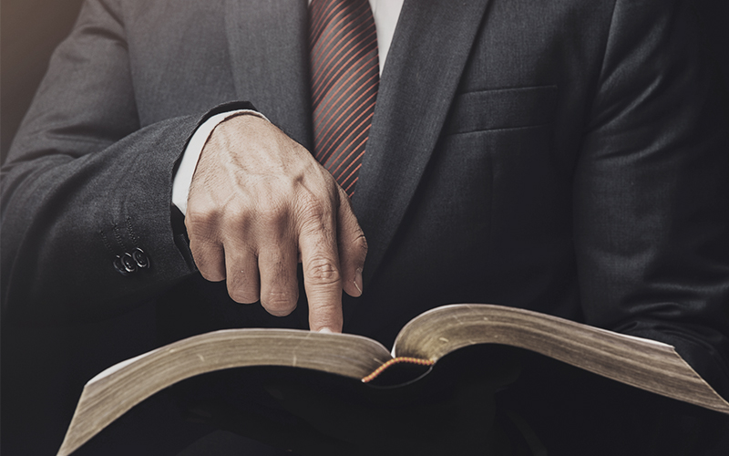 Man pointing at an open Bible